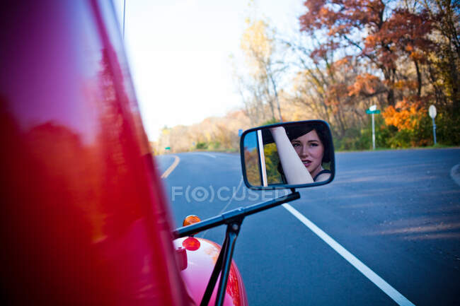 Reflection of woman in wing mirror — Stock Photo