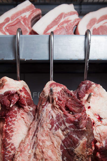 Pork and beef on hooks — Stock Photo