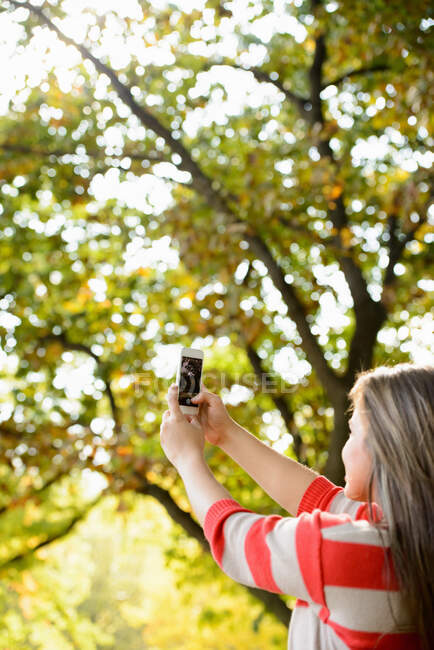 Femme prenant une photo avec téléphone portable — Photo de stock