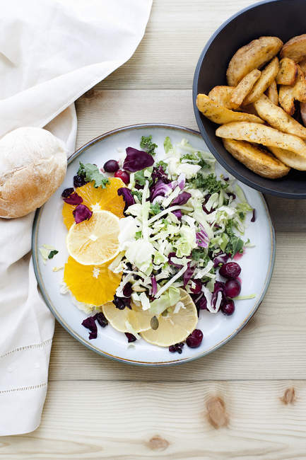Assiette de salade avec bol de pommes de terre rôties sur la table — Photo de stock