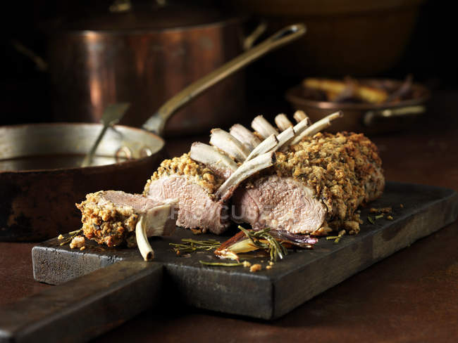 Cremagliera intagliata di agnello con rosmarino sul tavolo della cucina — Foto stock