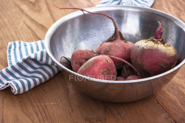Metal bowl of raw beetroots with cloth napkin on table — Stock Photo