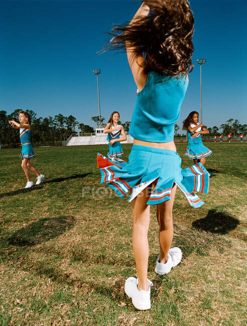 Cheerleaders performing dance routine on sports field — Stock Photo