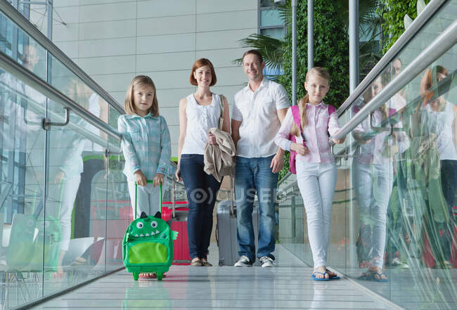 Family in airport with luggage — Stock Photo