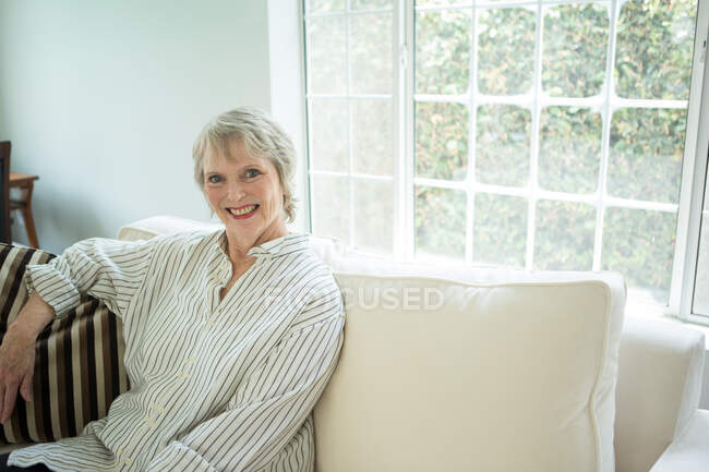 Senior mulher no sofá, retrato — Fotografia de Stock