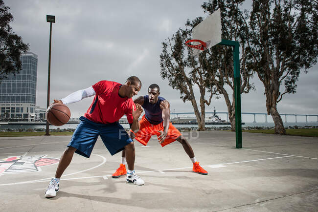Jovens jogadores de basquete jogando na quadra — Fotografia de Stock