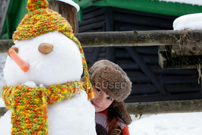 Жінка ховається за сніговиком — стокове фото