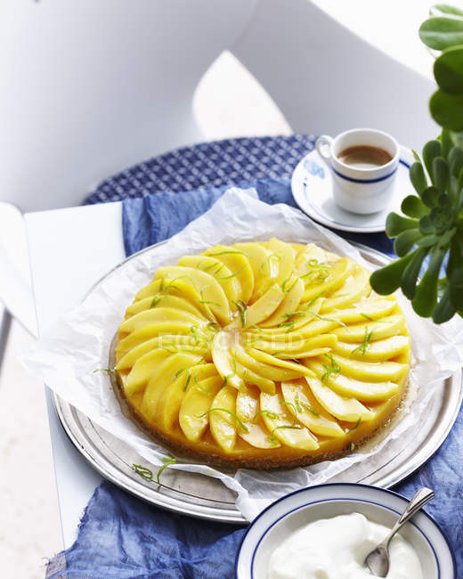 Spiced mango tart with coffee cup on table — Stock Photo