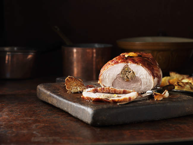Pato deshuesado con cerdo y cuchillo sobre tabla de madera - foto de stock