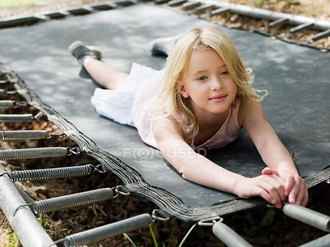 Menina deitada no trampolim — Fotografia de Stock