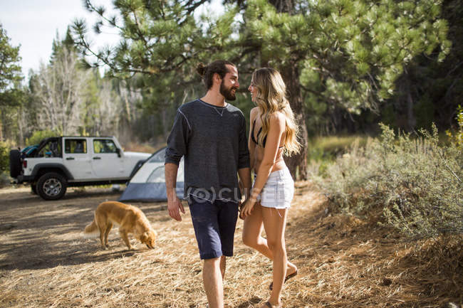 Romantic young couple holding hands in forest campsite, Lake Tahoe, Nevada, USA — Stock Photo
