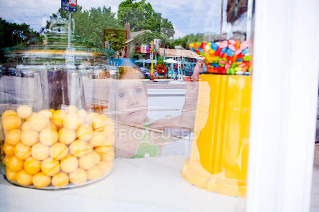 Junges Mädchen greift in Süßwarenladen nach Süßigkeiten — Stockfoto