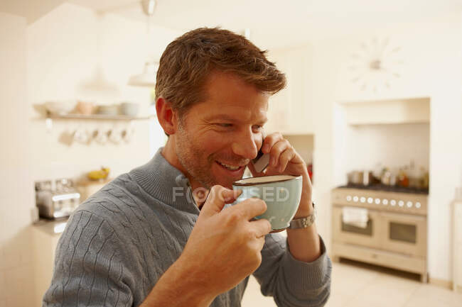Hombre en el teléfono bebiendo café - foto de stock