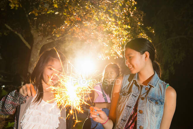 Girl with sparkler at night — Stock Photo