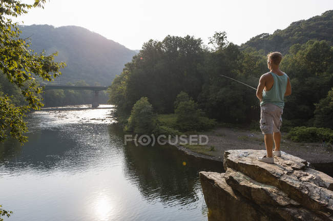 Young man fishing from rock ledge, Hamburg, Pennsylvania, USA — Stock Photo