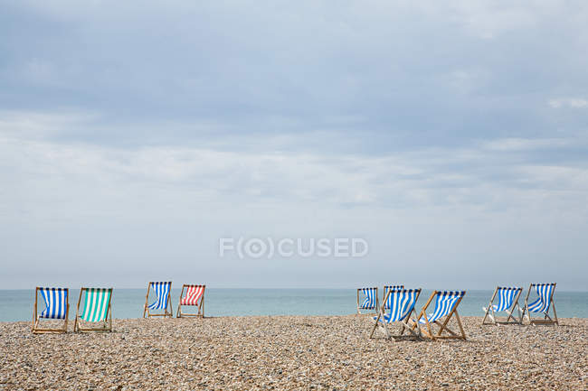 Порожні крісла на пляжі з хмарним небом — стокове фото