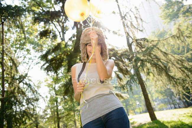 Mulher carregando balões no parque — Fotografia de Stock