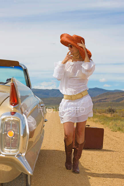 Женщина автостопом по пустынной дороге — стоковое фото