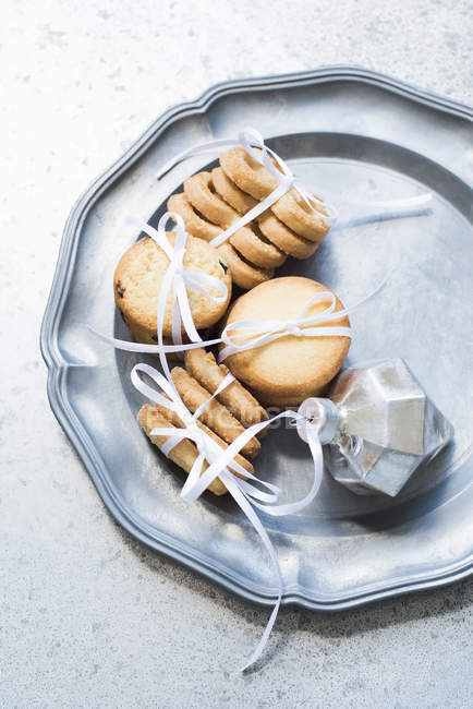 Vista dall'alto dei biscotti frolla legati con nastro bianco sul piatto da portata in argento — Foto stock