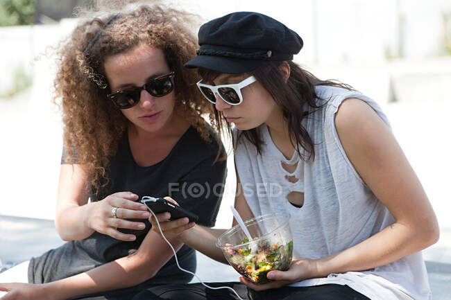Friends looking at mp3 player — Stock Photo