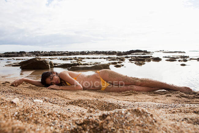 Frau liegt am Strand — Stockfoto