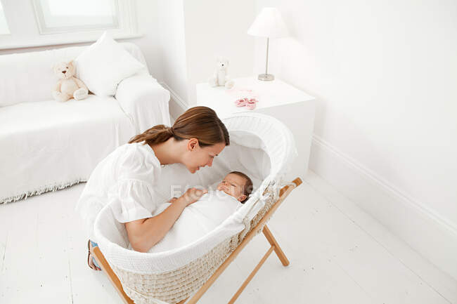 Mother with baby in bassinet — Stock Photo