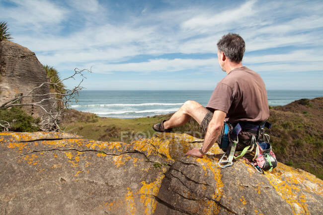 Скалолаз на вершине скалы с пейзажем, Руапуке, Рэглан, Новая Зеландия — стоковое фото