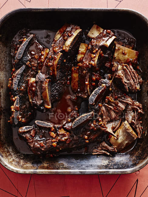 Roasting tin of short ribs braised in black sauce — Stock Photo