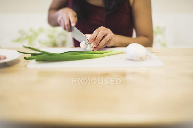Young woman slicing mushroom, mid section — Stock Photo