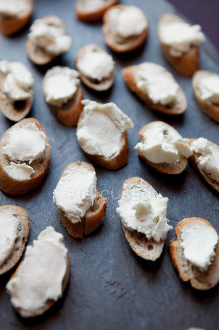 Goats cheese on baguette slices, close up shot — Stock Photo