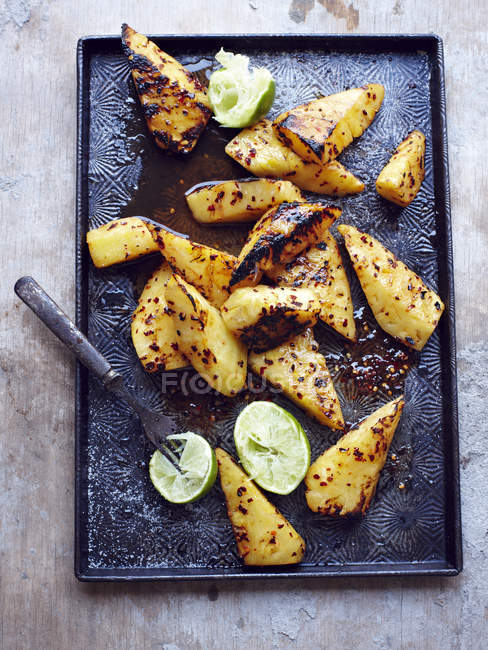 Tray of grilled pineapple with lime — Stock Photo