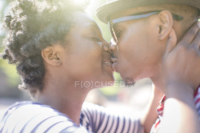 Primer plano de pareja joven besándose en parque - foto de stock