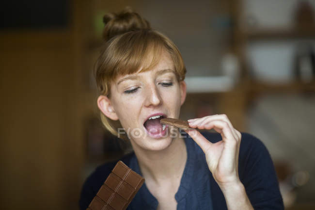 Jeune femme mangeant du chocolat — Photo de stock
