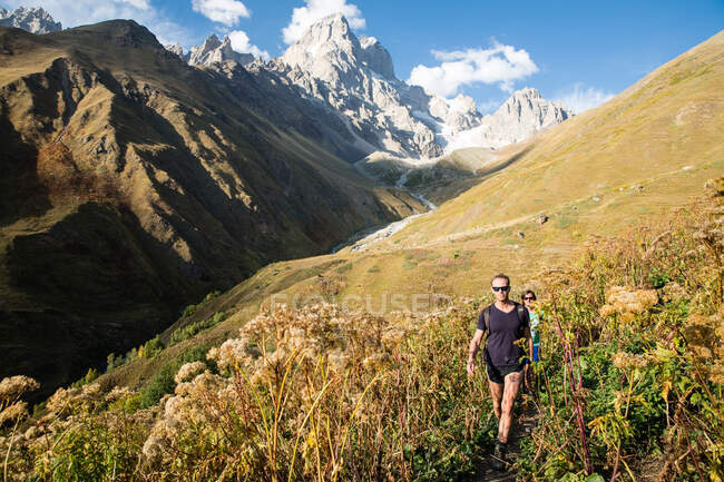 Male hikers hiking in mountain valley landscape, Svaneti, Georgia — Stock Photo