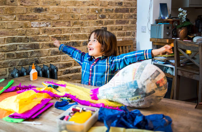 Niño decorando piñata en casa - foto de stock