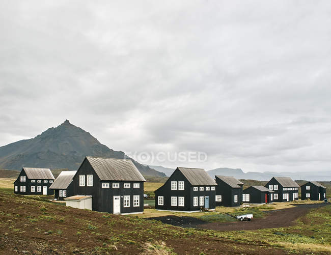 Автентичні ісландські будинки з гірським пейзажем і хмарним небом — стокове фото