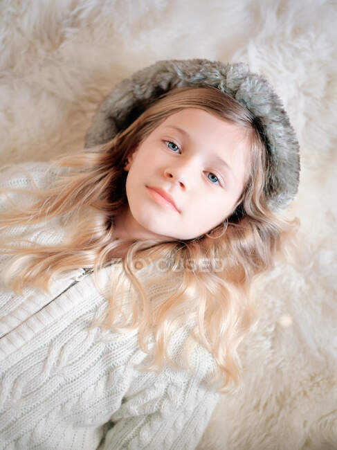 Молода дівчина-підліток лежить на хутряному килимку, портрет — стокове фото
