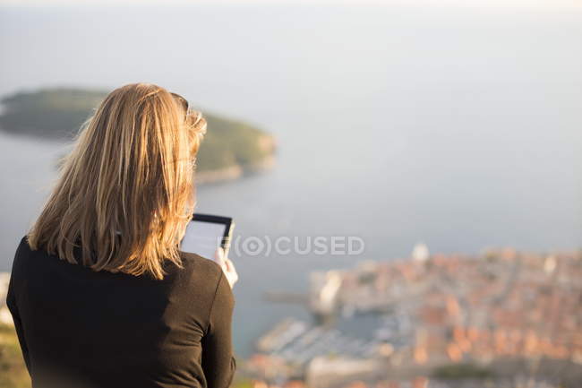 Visão traseira da mulher usando tablet digital, Dubrovnik, Croácia — Fotografia de Stock