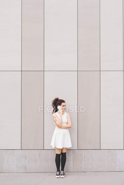 Femme devant le bâtiment faisant un appel téléphonique, Milan, Italie — Photo de stock