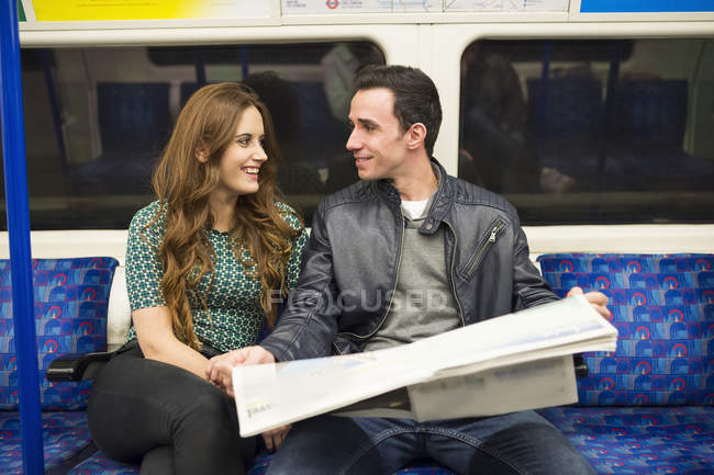 Casal no trem ler jornal — Fotografia de Stock