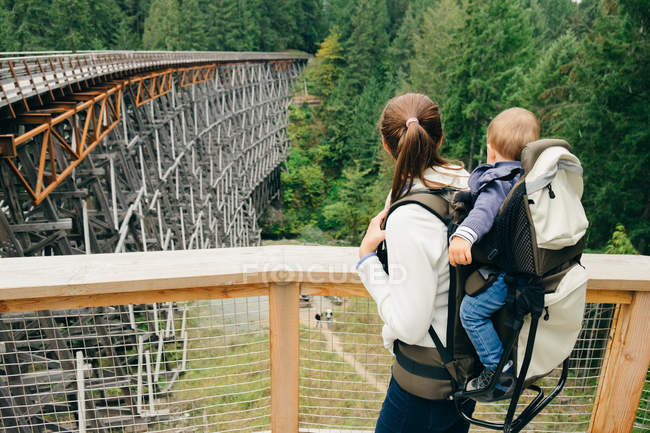 Jovem mulher carregando filho nas costas, Kinsol Trestle Bridge, British Columbia, Canadá — Fotografia de Stock