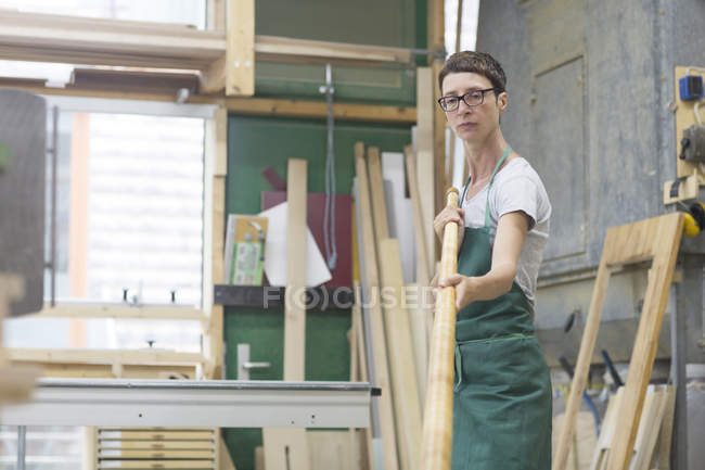 Mujer en taller revisando tubo alphorn - foto de stock