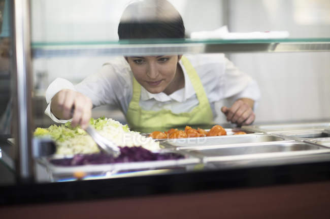 Junge Frau bereitet Essen in Fast-Food-Laden zu — Stockfoto