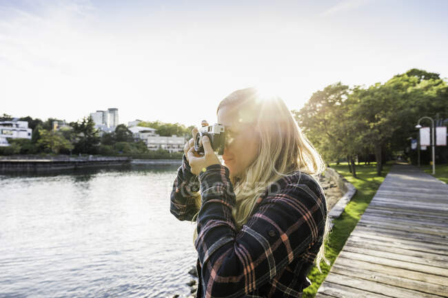 Femme prenant des photos sur le front de mer à Granville Island, Vancouver, Canada — Photo de stock