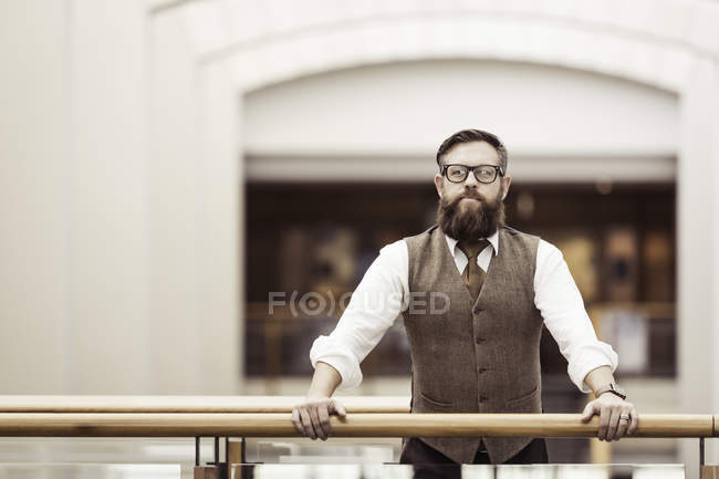 Portrait of bearded businessman wearing tweed waistcoat on office balcony — Stock Photo