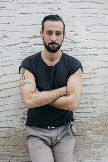Ritratto di uomo medio adulto con le braccia incrociate appoggiate alla parete — Foto stock