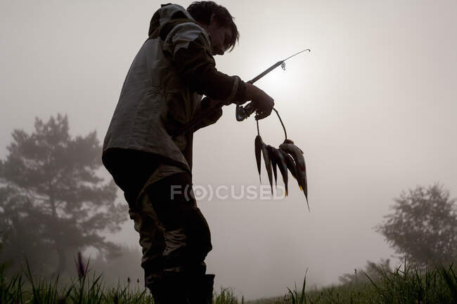 Fisherman holding fresh caught fish — Stock Photo