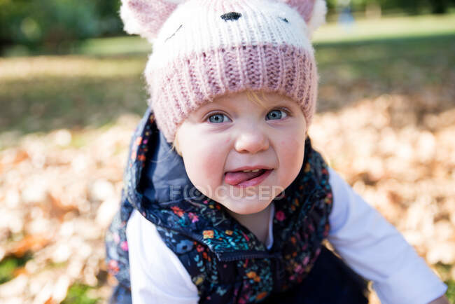 Portrait de bambin femelle avec la langue dans le parc — Photo de stock