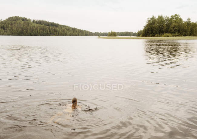 Frau schwimmt im See, orivesi, Finnland — Stockfoto