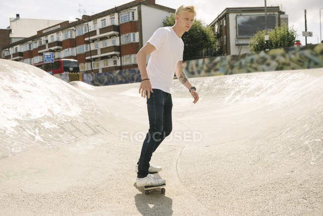Giovane skateboarder skateboard maschile in skatepark — Foto stock